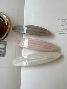 Three-piece set of acetate hair clips with elegant marble patterns and gold logo