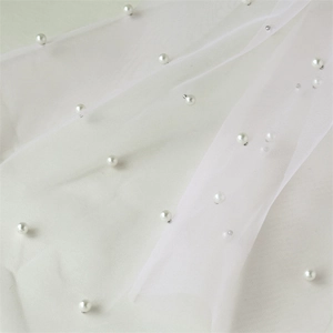 Vue détaillée d'un tissu en maille blanche orné de perles élégantes et de paillettes argentées
