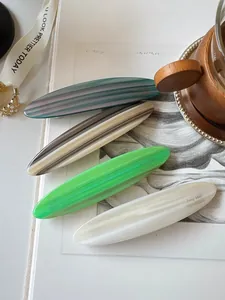 Detailed close-up of handmade acetate hair clips with marbled texture and French style design