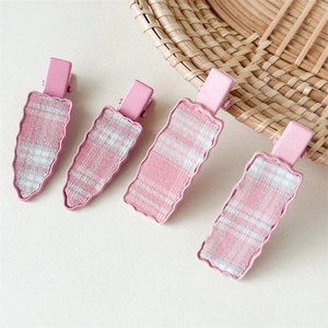 Close-up of pink checkered hair clips set featuring plaid fabric and carrot designs