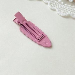 Pink checkered metal hair clip with a wave-edge base and matte finish for women