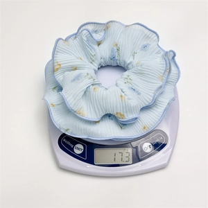 Blue floral scrunchie on electronic scale showing product weight of 17.3g