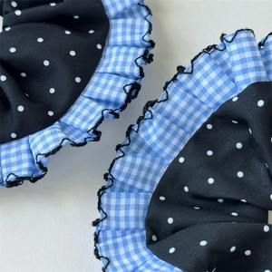 Detail von blauem Gingham und Polka Dot Haargummis mit schwarzem Spitzenbesatz