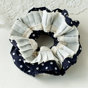 Detail aus Polka-Dot-Chiffon mit weißem Plissee-Tüll und beiger Spitzenkante
