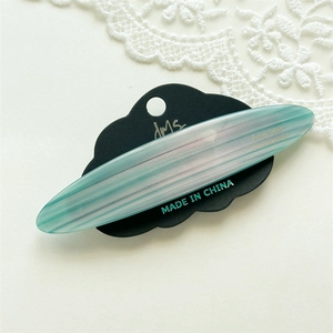 Detail view of acetate hair clip with blue and white marble texture on a display card