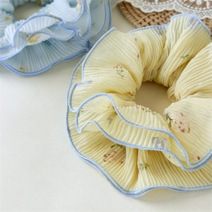 Detail of floral chiffon scrunchies with pleated texture and fine blue edge stitching