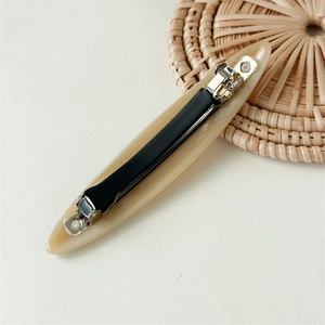 Close-up of beige acetate spring hair clip with durable black metal mechanism