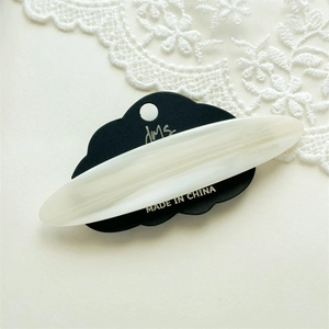Close-up of a pearlescent cream acetate hair clip on a minimalist display card