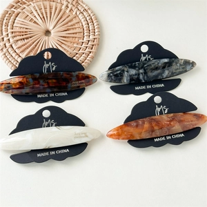 Detail of elegant acetic acid marble hair clips in various patterns on black display cards