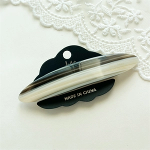Detailed macro view of the acetate hair clip featuring marble stripes and cloud-shaped card