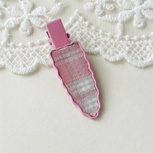 Detailed view of pink plaid fabric carrot-shaped hair clip with scalloped metal edges