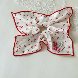 Detailed shot of cherry print scrunchie with red bow and heart charm decoration