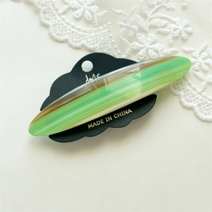 Macro view of green and brown marbled acetate hair clip with high gloss finish on lace