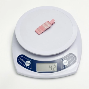 Pink plaid duckbill hair clip weighing 4.2g on a digital scale for precise product detail