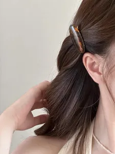 Detail of tortoiseshell acetate hair clip with France engraving and silver heart earring