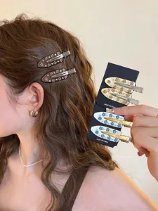 Detailed view of acetate flower hair clips with sparkling rhinestones and white faux pearls