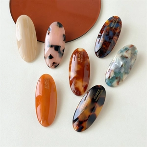 Set of 7 oval acetate hair clips in leopard, marble, and tortoiseshell patterns