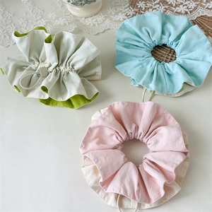 Detail of drawstring oversized scrunchies in pastel pink, blue, and green cotton fabric