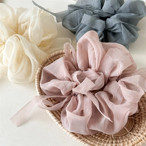 Detail of jumbo textured chiffon scrunchies with ribbons in soft Morandi colors