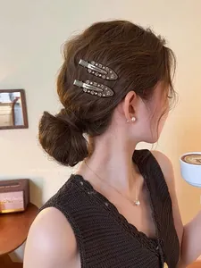 Detail of brown acetate hair clips with crystal flower patterns on model's side hair