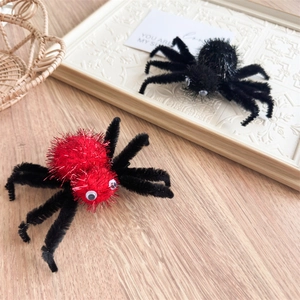 Gros plan de pinces à cheveux araignée Halloween avec corps en velours rouge et noir