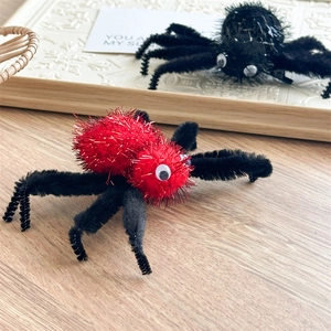 Détail des pinces à cheveux araignée en peluche avec yeux mobiles sur un plateau