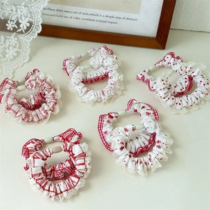 Red and white polka dot and plaid hair scrunchies set with lace trim on a white table