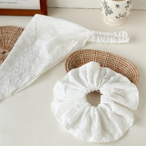 Detail of white cotton lace embroidery floral headband and matching hair scrunchie set
