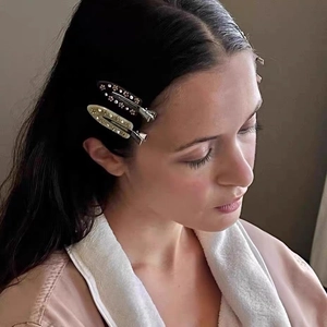 Close-up of marble acetate hair clips with crystal flower patterns on model's hair