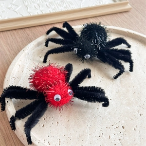 Gros plan de pinces à cheveux araignée d'Halloween réalistes en peluche rouge et noir