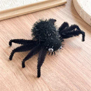 Détail d'une araignée en peluche noire pour Halloween avec des fils argentés et yeux mobiles