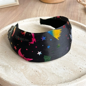 Detailed macro view of wide headband with rainbow star, crescent moon, and wing patterns