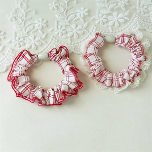 Detail of red and white plaid hair scrunchies with delicate lace trim and white bead accents