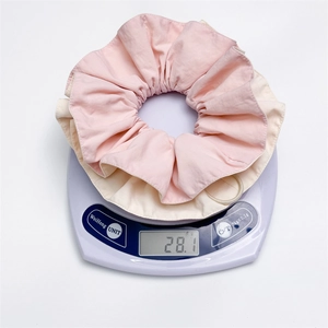 Weight measurement detail showing 28.1g for pink and beige pleated scrunchie hair tie