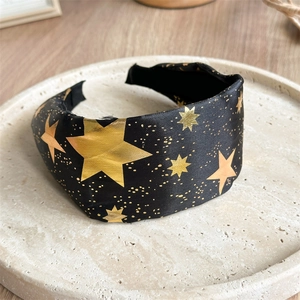Detail of black satin wide headband with gold stars and glitter for Halloween parties