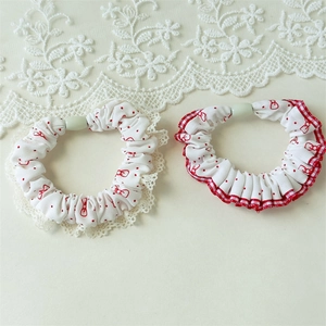 Detail of red polka dot and bow scrunchie set with sweet lace edges and cotton texture
