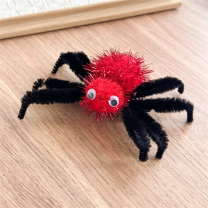Vue de dessus d'une pince à cheveux araignée en peluche pour Halloween avec corps rouge vif