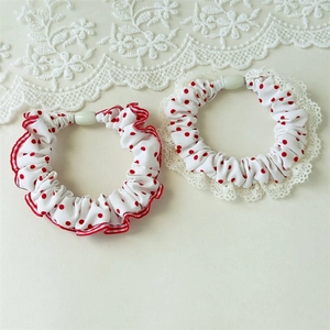 Detailed view of red polka dot hair ties with lace edges and ruffled fabric texture