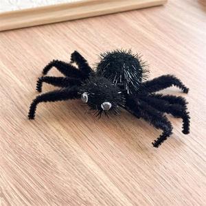 Détail d'une pince à cheveux araignée en peluche noire avec des reflets argentés