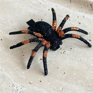 Macro shot of Halloween spider hair clip with glitter spots and black alligator grip