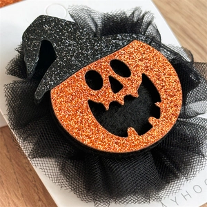 Détail d'une pince à cheveux citrouille d'Halloween avec chapeau de sorcière noir