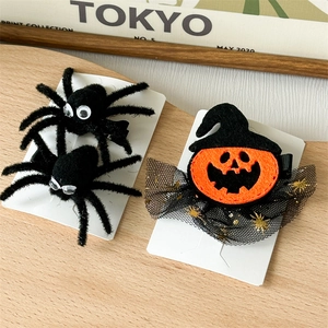 Detail of Halloween hair clips featuring a plush spider and pumpkin witch hat on card