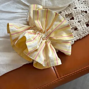 Chic striped yellow and pink fabric scrunchie with elastic ruffles and soft texture