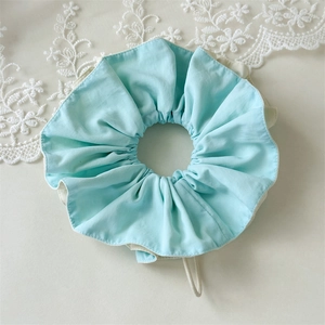 Detailed macro view of mint green pleated hair scrunchie with soft ruffled fabric texture