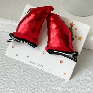 Detail of red shiny devil horns hair clips on display card with festive decorations