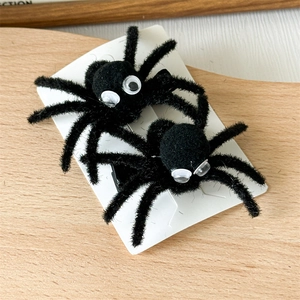 Detail view of black plush spider hair clips with realistic eyes for Halloween party hair