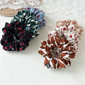Détails de chouchous en tissu aux motifs floraux et animaliers sur fond de dentelle