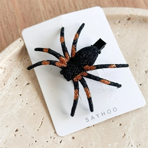 Detailed view of Halloween spider hair clip with orange sequins on high-quality display card