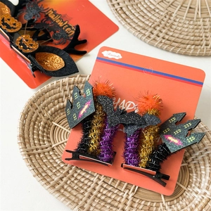 Detail view of Halloween hair clips featuring bat, pumpkin and spider designs with glitter finish