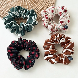 Lot de quatre chouchous en tissu à motifs floraux en vert, blanc, noir et caramel